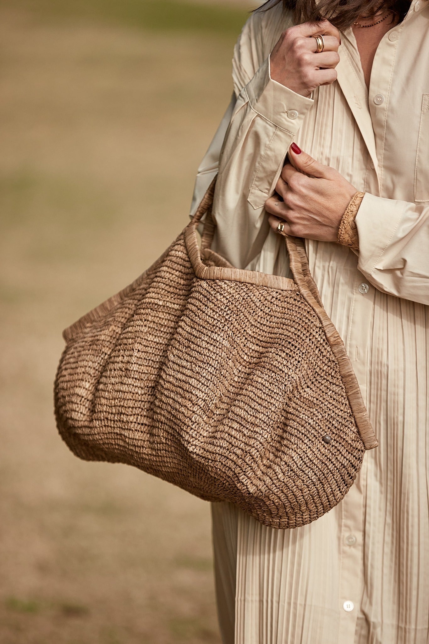 Aina Bag L Tea van Made in Mada gedragen aan de arm, handgeweven raffiatas met natuurlijke uitstraling