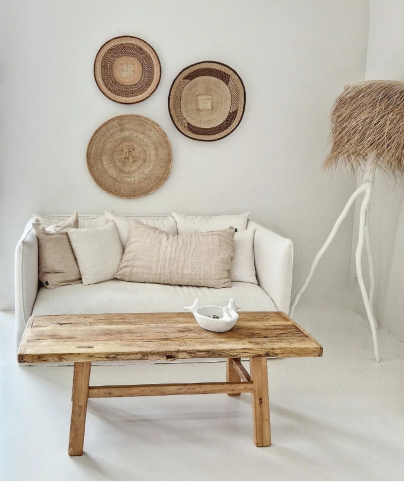 Tonga baskets boven een bank in een wit interieur