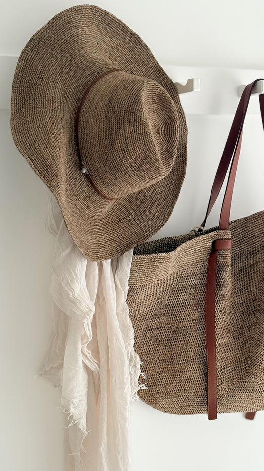 Aziz Tan Leather Hat Tea by Made in Mada styled with a raffia bag and soft white linen