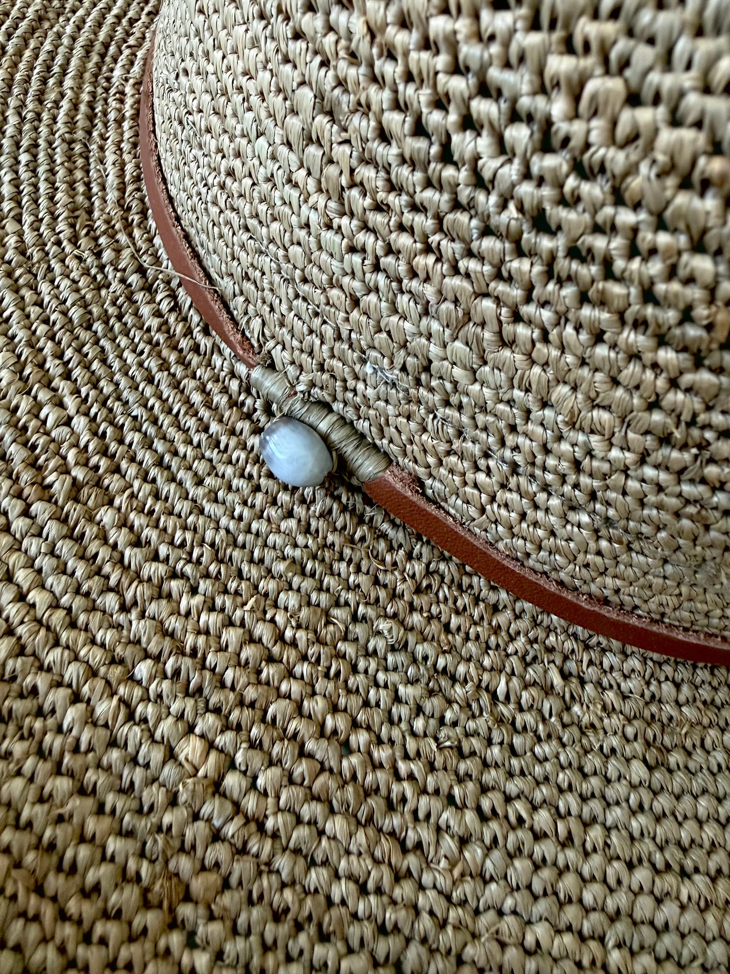 Detail foto van de leren band van de raffia hoed Elya tan leather in tea kleur van Made in Mada