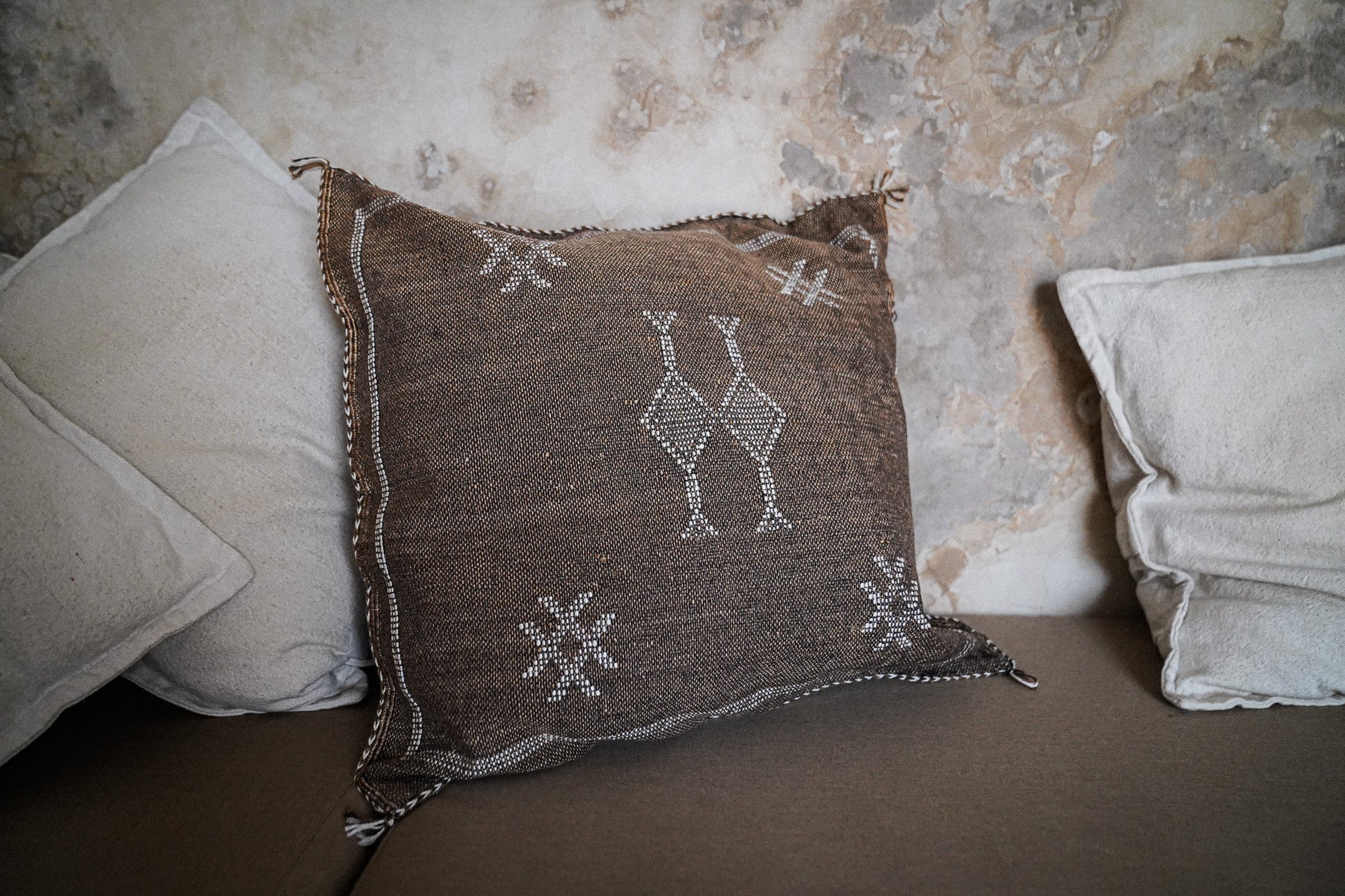 Marokkaans sabra silk kussenhoes uit de Earth brown collectie met naturel kussens met een geleefde achtergrond
