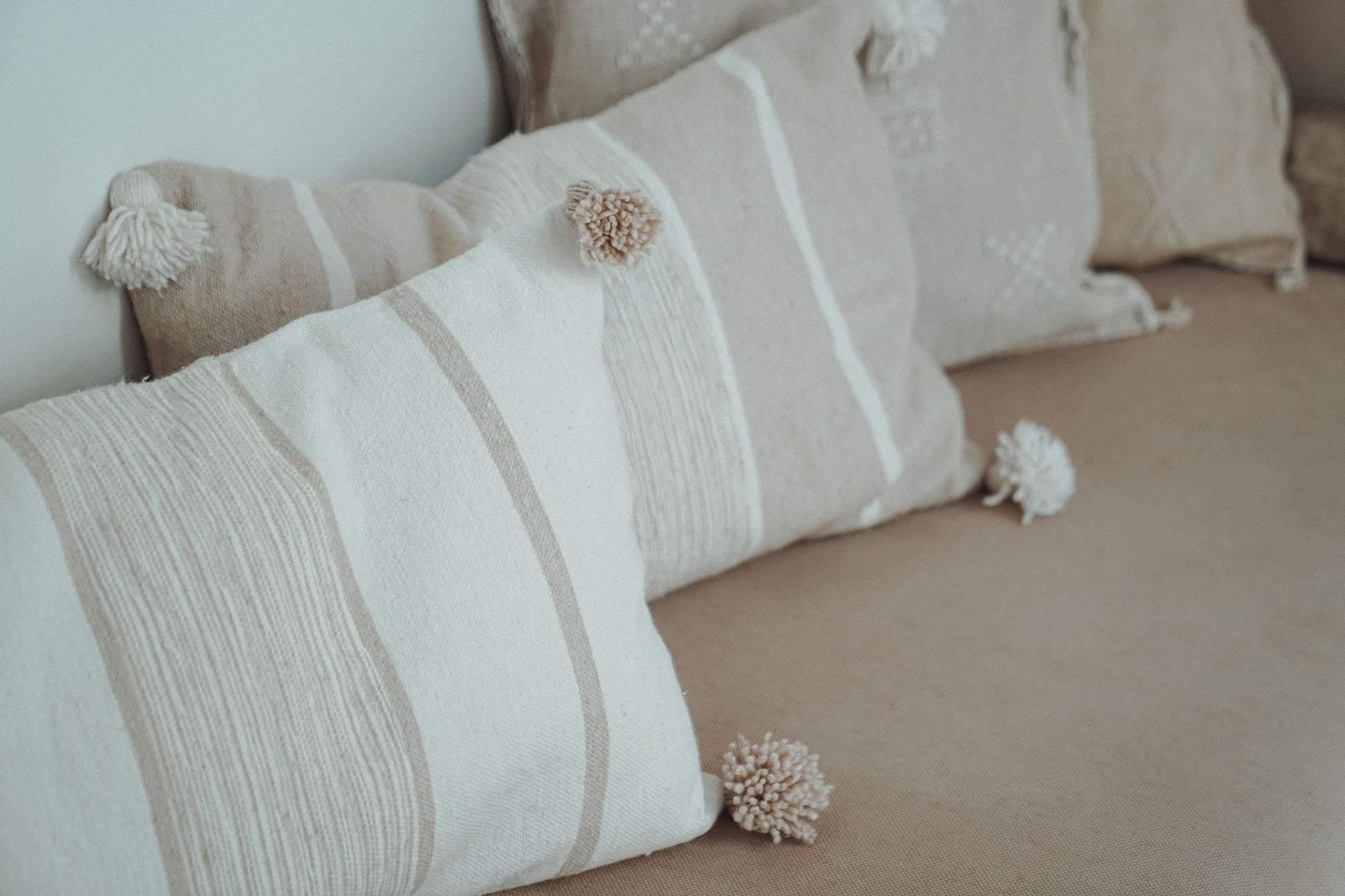 Marokkaans pompom kussen detail_off-white en beige 40x60 op bank