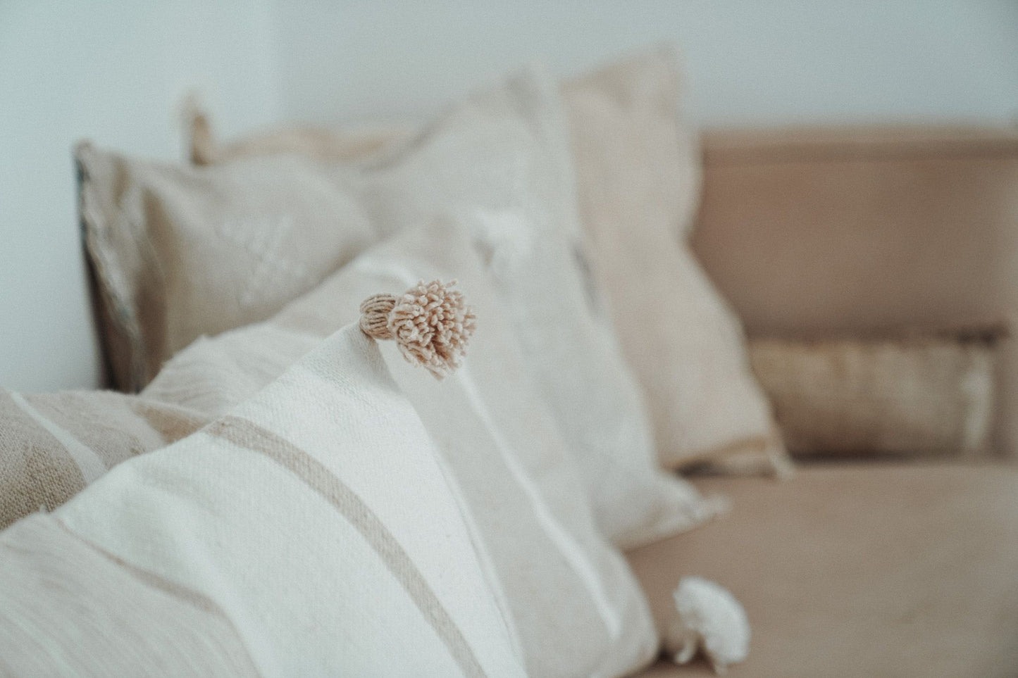 Marokkaans pompom kussen detail_off-white en beige 40x60 op bank