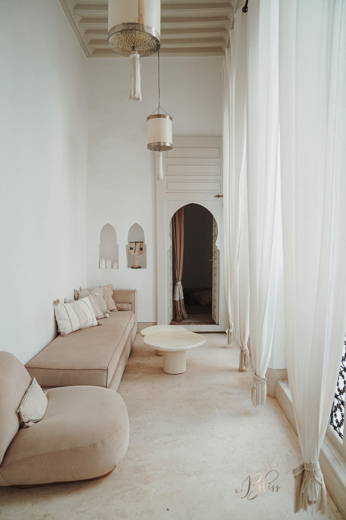 Marokkaanse pompom kussens in off-white en beige op sofa in warm, licht Marokkaans interieur