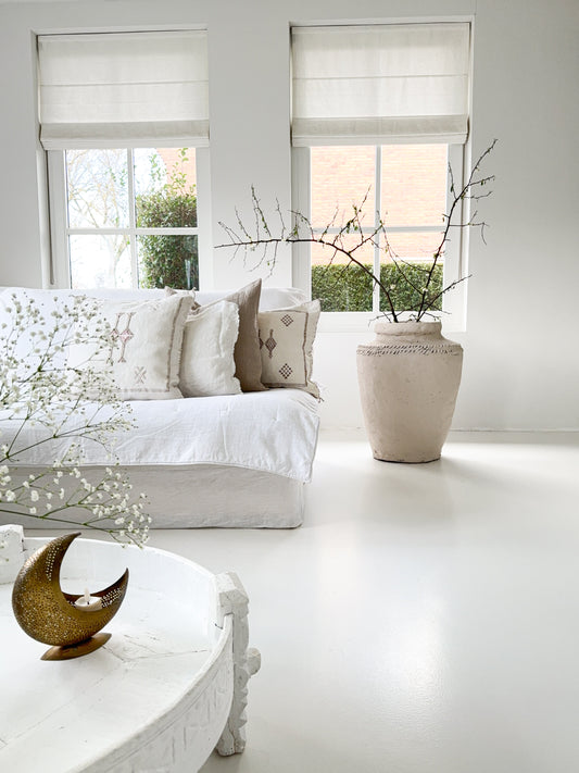 XL aardewerk pot in mushroom kleur in een wit interieur naast een linnen bank met linnen en sabra silk kussens.