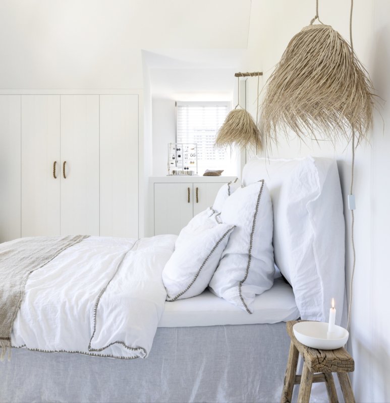 Palmleaf hanglampen Cloche small aan weerszijden van een bed met wit linnen beddengoed