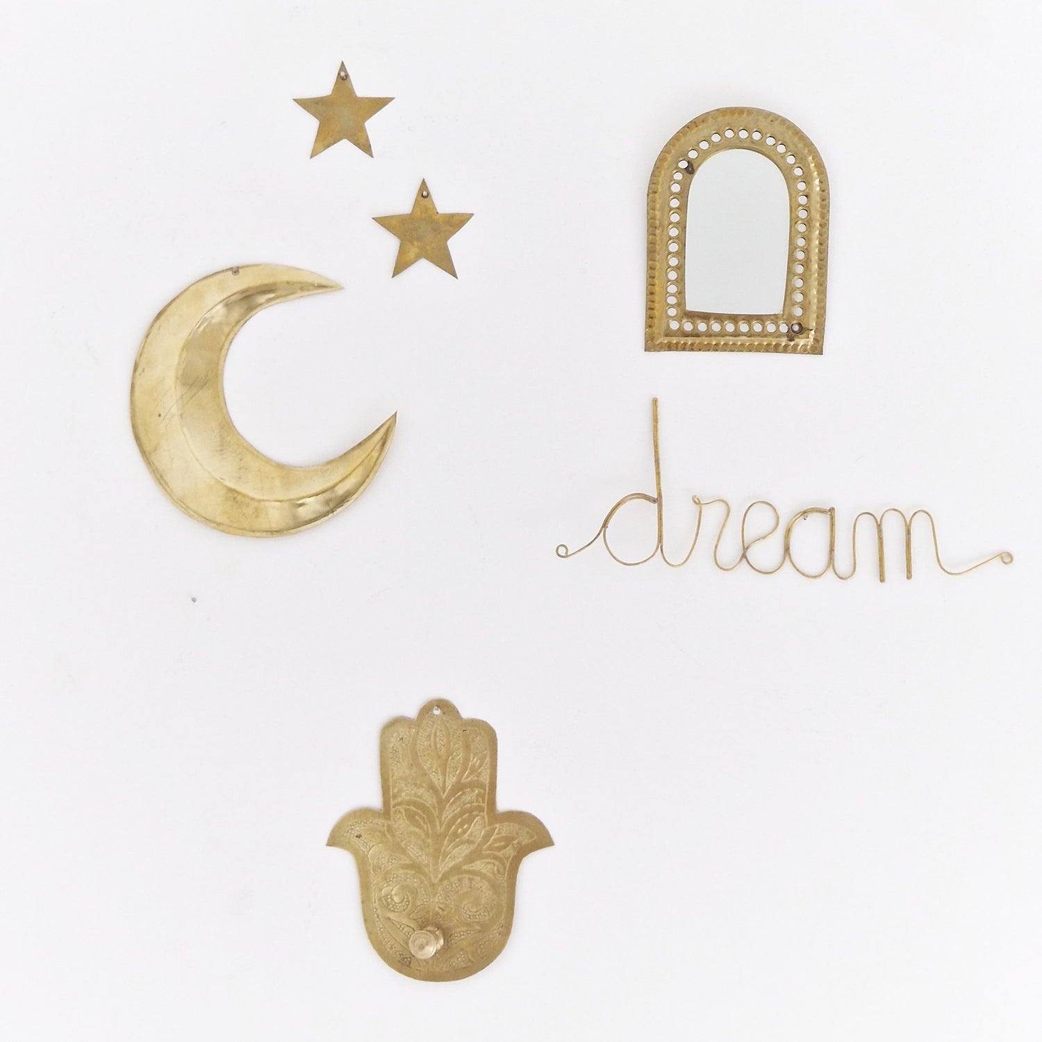 Sfeerfoto van het messing draad woord Dream gecombineerd met messing maantje, sterren, hamsa handje en spiegeltje